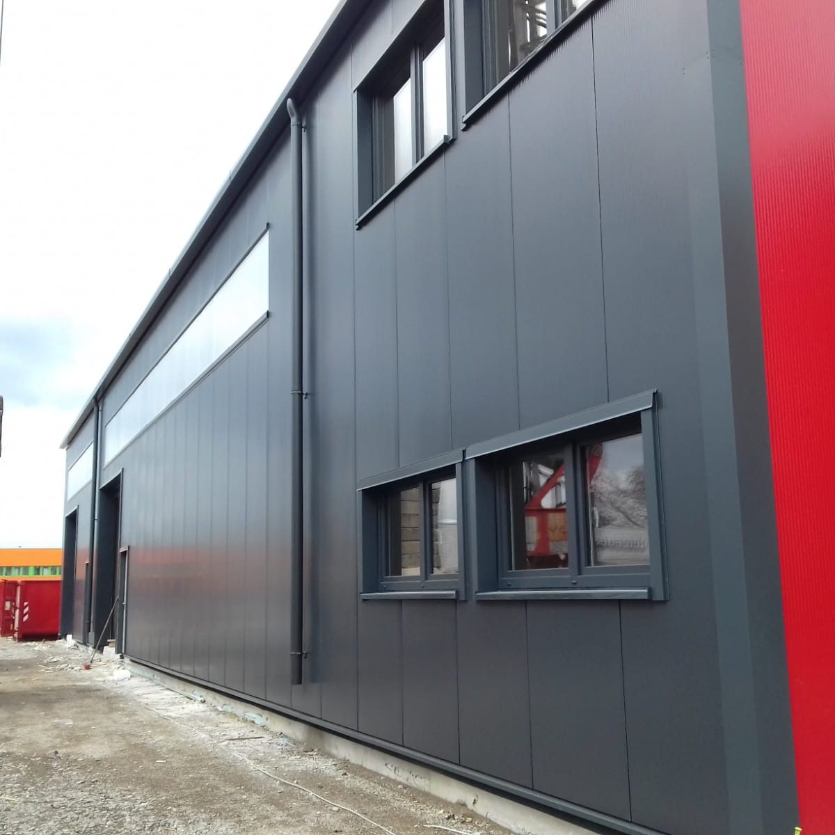 Fassade Industriehalle Fassade aus Sandwichpaneele in grau und rot